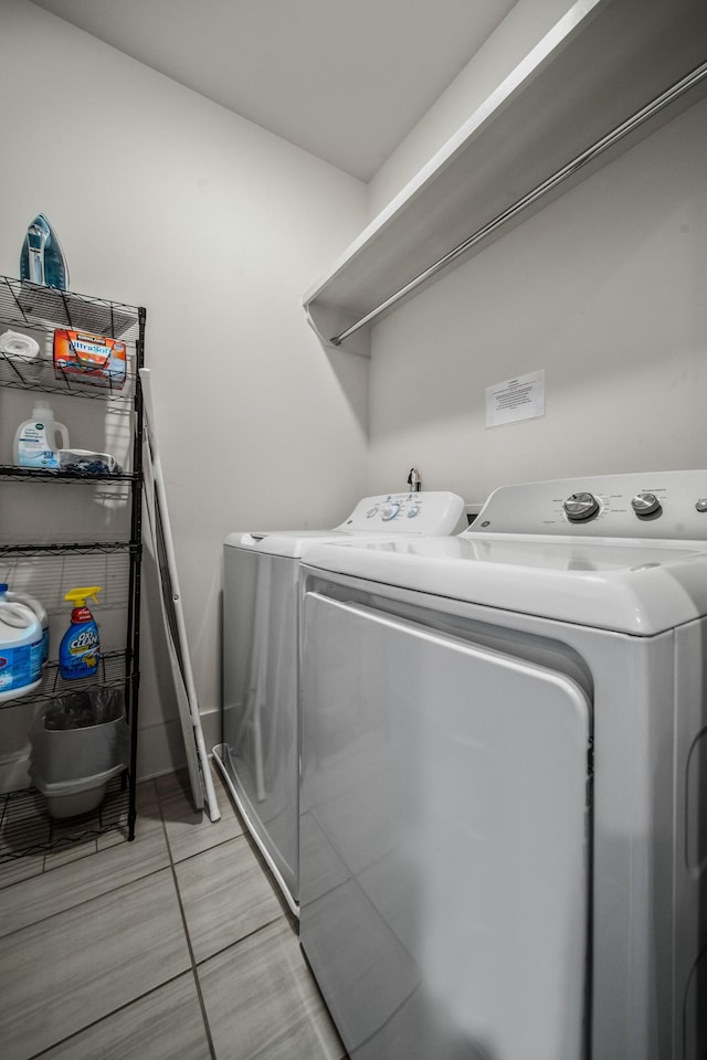 laundry room with separate washer and dryer and light tile patterned floors