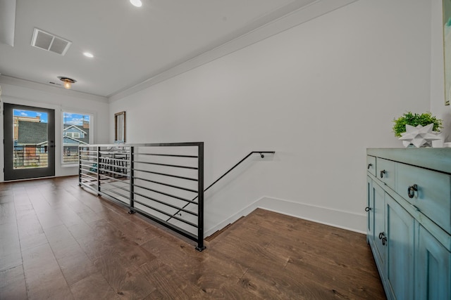 staircase with hardwood / wood-style floors and ornamental molding