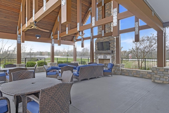 view of patio with an outdoor living space with a fireplace, a gazebo, and ceiling fan