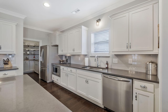 kitchen with sink, tasteful backsplash, dark hardwood / wood-style flooring, white cabinets, and appliances with stainless steel finishes