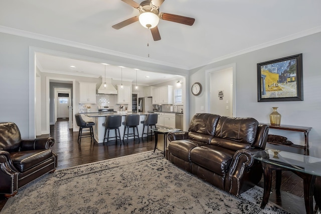 living room featuring ornamental molding, ceiling fan, and dark wood-type flooring