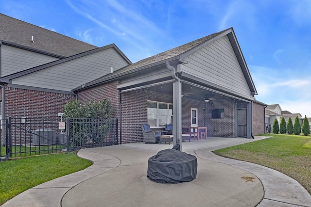 rear view of property with a lawn, ceiling fan, and a patio area