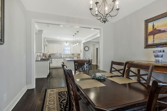 dining room with a chandelier, crown molding, dark wood-type flooring, and sink