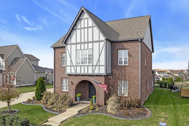 tudor-style house featuring a front yard