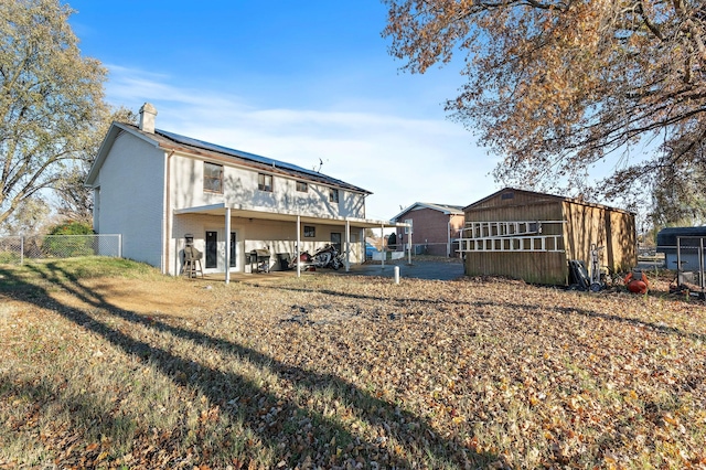 rear view of property featuring a patio and an outdoor structure