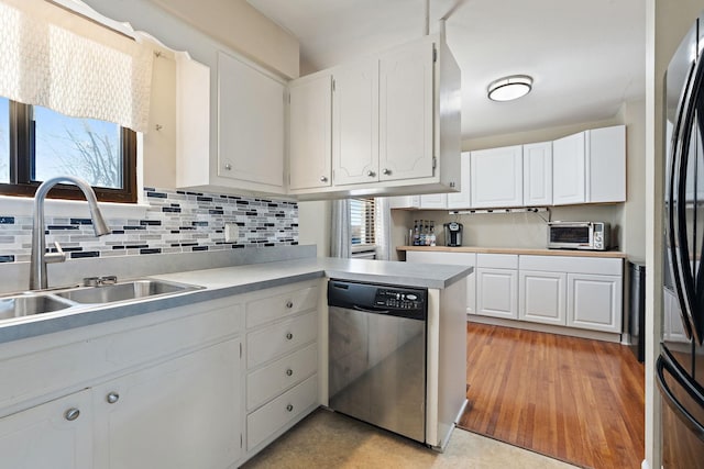 kitchen with a healthy amount of sunlight, sink, white cabinetry, and stainless steel appliances