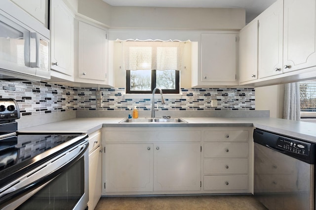 kitchen featuring decorative backsplash, white cabinetry, sink, and appliances with stainless steel finishes