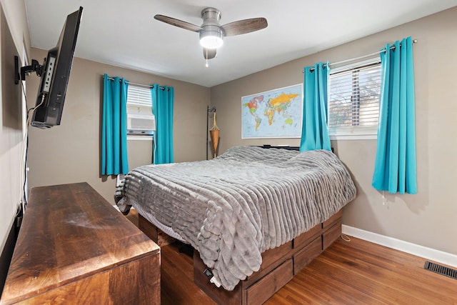 bedroom featuring multiple windows, ceiling fan, and dark hardwood / wood-style flooring