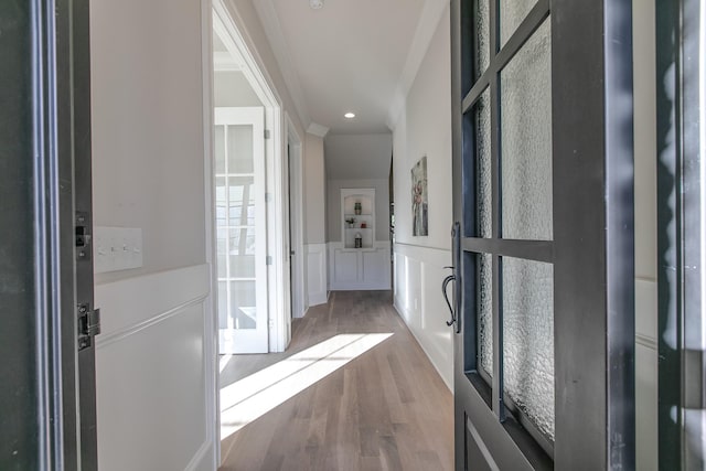 hallway with wood-type flooring and crown molding