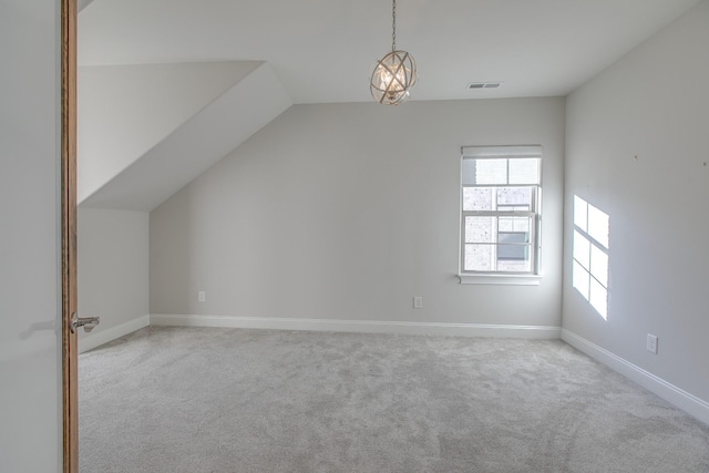 bonus room featuring light carpet, a notable chandelier, and lofted ceiling