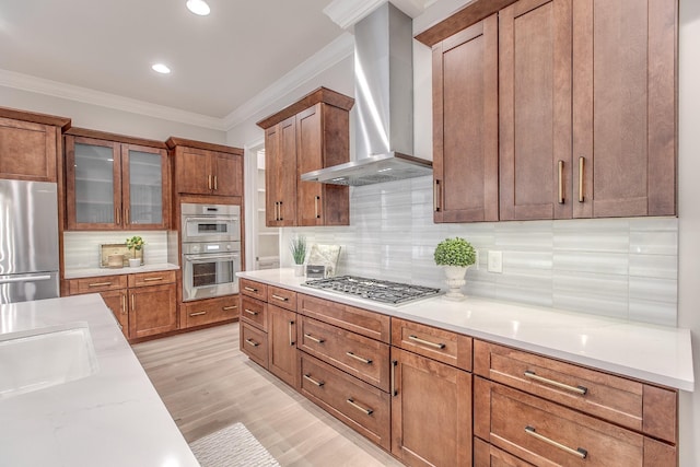 kitchen with backsplash, ornamental molding, stainless steel appliances, and wall chimney exhaust hood