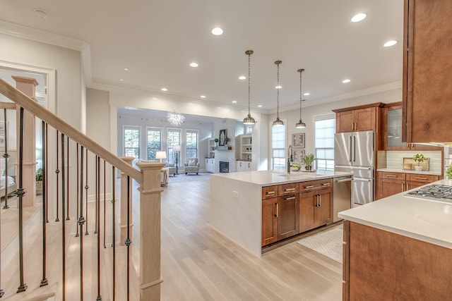 kitchen with crown molding, stainless steel appliances, decorative light fixtures, and sink