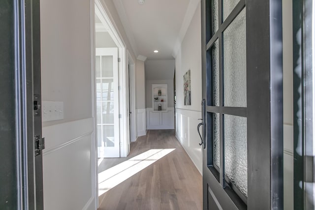 corridor featuring hardwood / wood-style flooring and ornamental molding