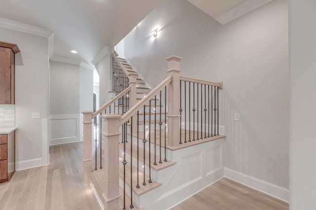 stairway featuring ornamental molding and hardwood / wood-style floors