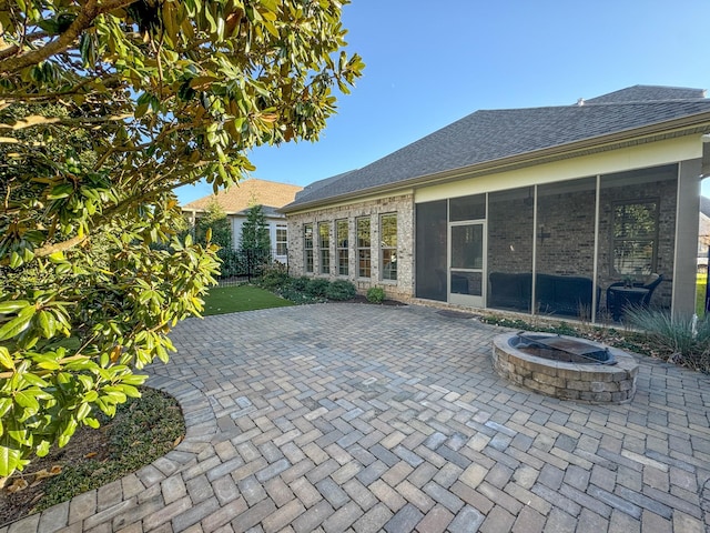 view of patio with a fire pit and a sunroom