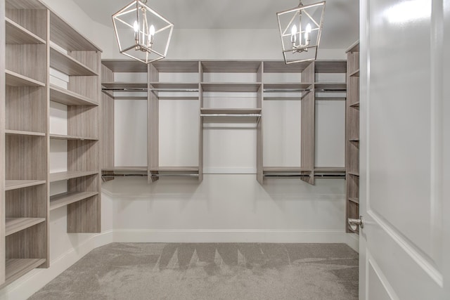 walk in closet with a chandelier and carpet