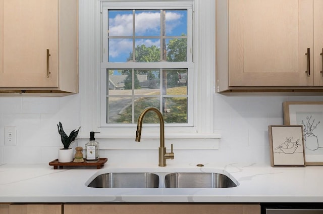 interior details with light stone counters, sink, and light brown cabinetry