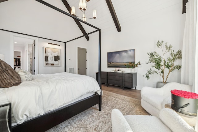 bedroom with beamed ceiling, high vaulted ceiling, a chandelier, and light wood-type flooring