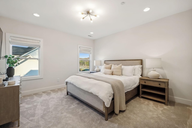 bedroom with light carpet and a chandelier