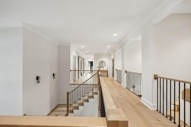 hallway with light hardwood / wood-style flooring and ornamental molding