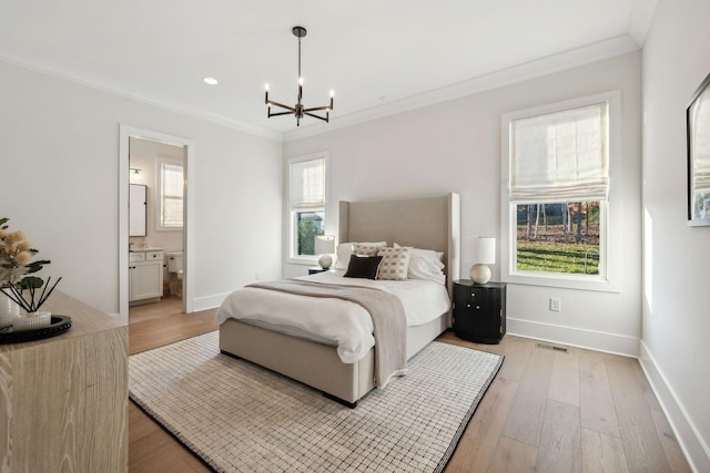 bedroom with ensuite bathroom, light hardwood / wood-style floors, a chandelier, and multiple windows