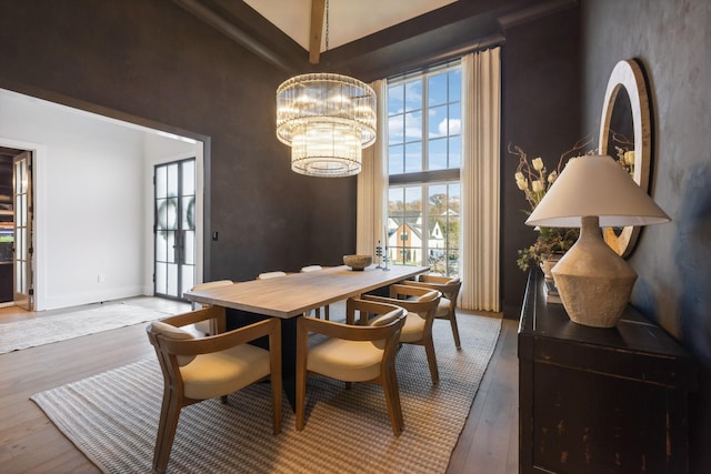 dining area featuring hardwood / wood-style floors, plenty of natural light, and an inviting chandelier