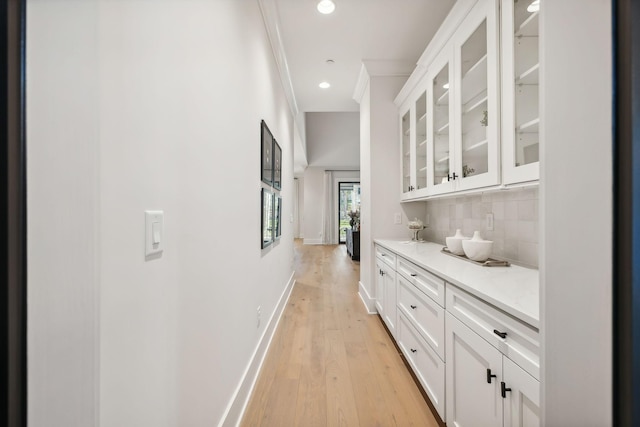 corridor featuring crown molding and light hardwood / wood-style floors