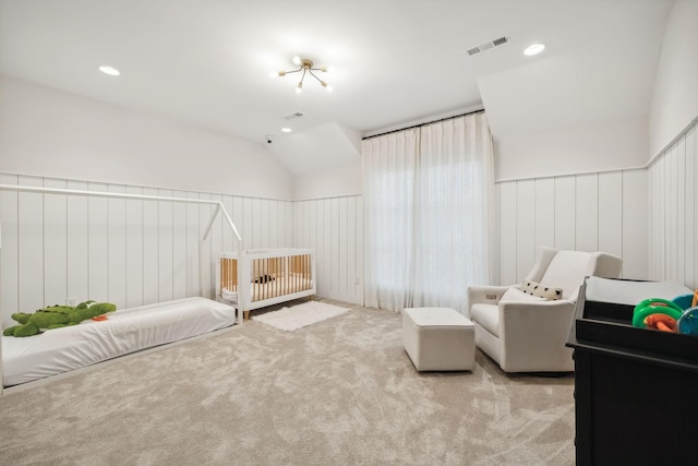 bedroom featuring wood walls, light colored carpet, and lofted ceiling