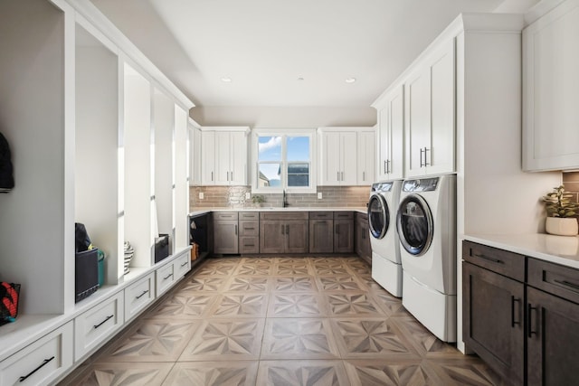 laundry room featuring cabinets, independent washer and dryer, and sink