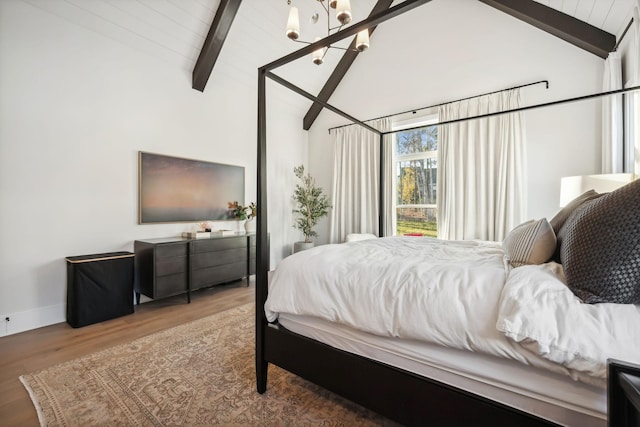 bedroom with hardwood / wood-style floors, high vaulted ceiling, an inviting chandelier, and beam ceiling