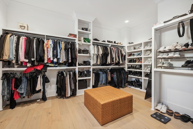 walk in closet with light hardwood / wood-style flooring