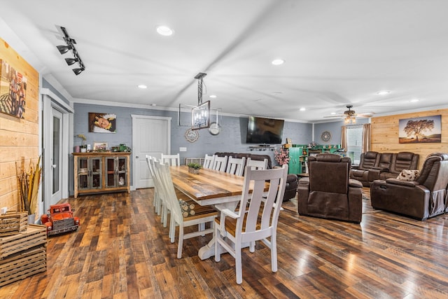 dining room with ceiling fan with notable chandelier, dark wood-type flooring, rail lighting, and crown molding