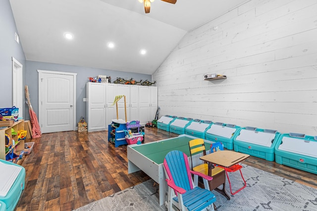 game room featuring ceiling fan, dark hardwood / wood-style flooring, vaulted ceiling, and wood walls