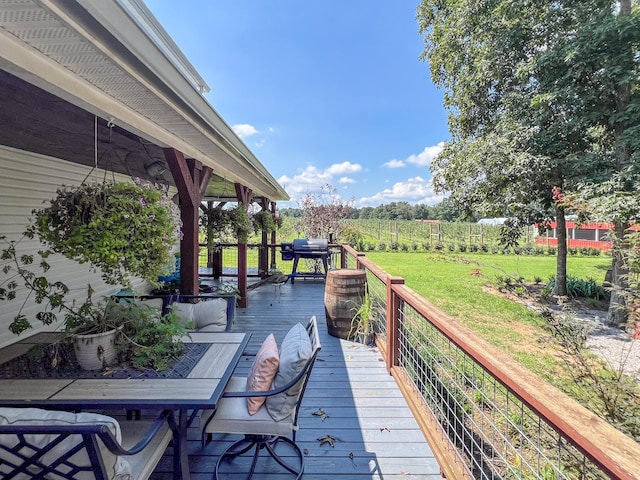 wooden terrace featuring a yard and a grill