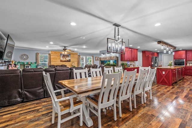 dining room with ceiling fan with notable chandelier, dark wood-type flooring, wooden walls, and a healthy amount of sunlight