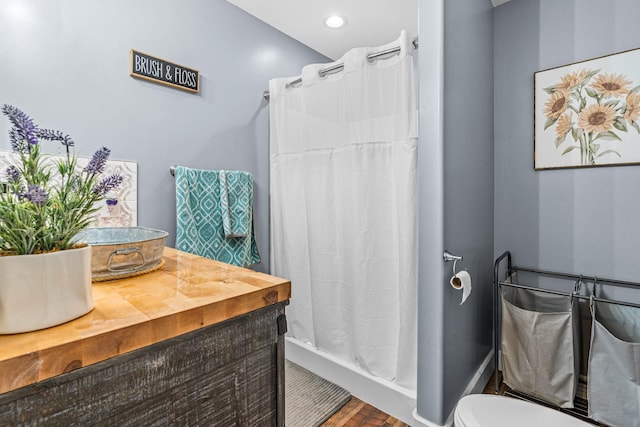 bathroom featuring toilet, hardwood / wood-style flooring, and walk in shower