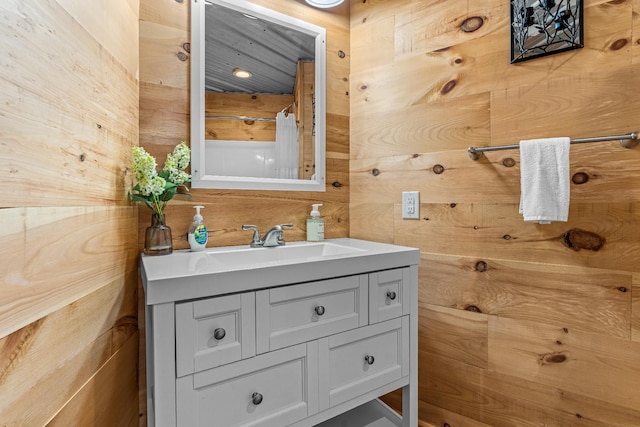 bathroom featuring vanity and wooden walls