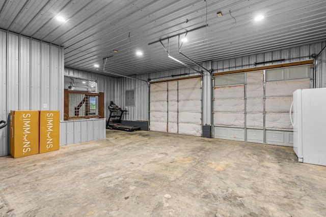 garage with electric panel and white fridge