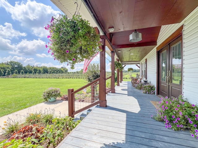 wooden terrace with a porch and a lawn