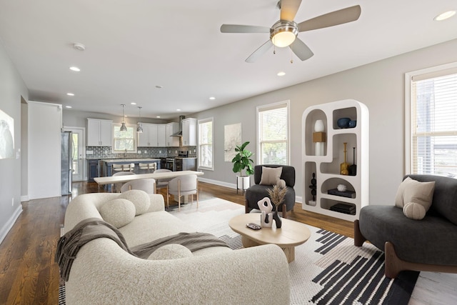 living room featuring ceiling fan, wood-type flooring, and sink