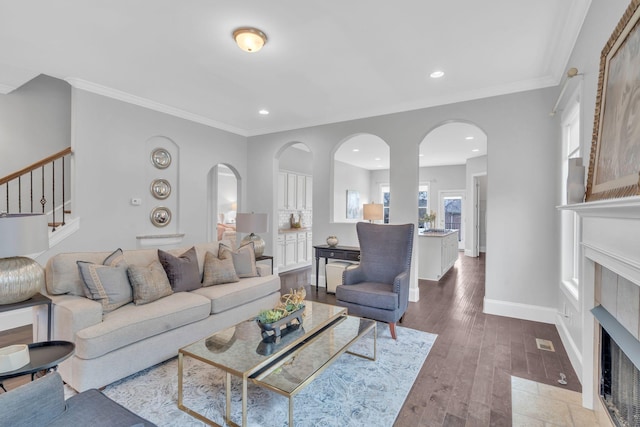 living room featuring crown molding, wood-type flooring, and a fireplace