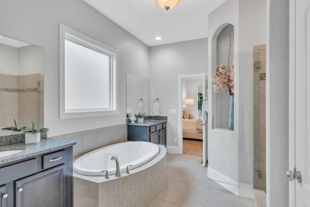 bathroom with tile patterned flooring, vanity, and shower with separate bathtub