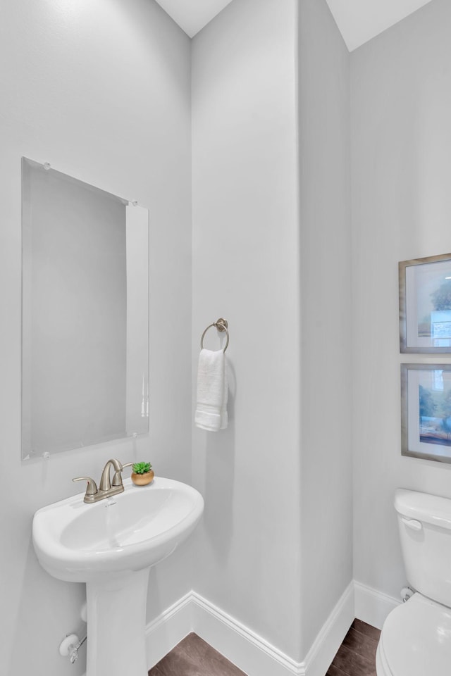 bathroom with toilet and wood-type flooring