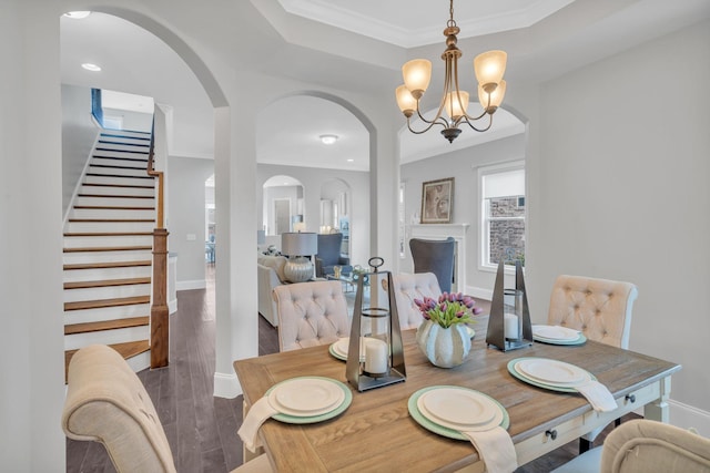 dining space with dark hardwood / wood-style floors, crown molding, and a notable chandelier