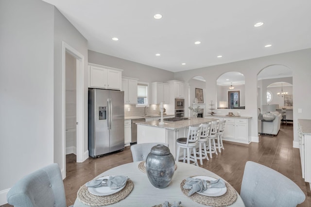 dining space featuring sink and dark wood-type flooring