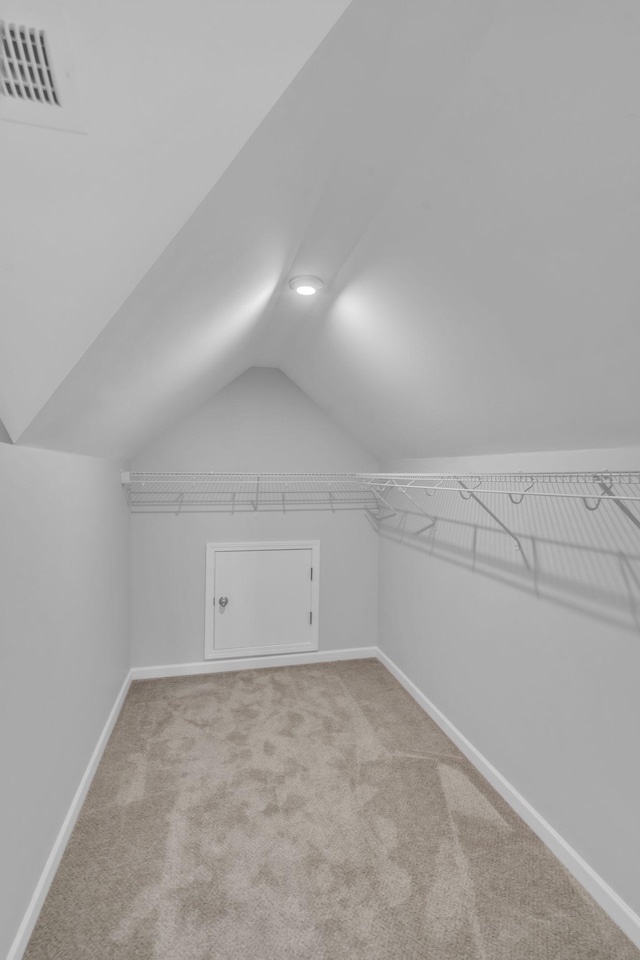 bonus room featuring light carpet and vaulted ceiling