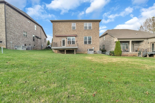 back of house featuring a lawn, a wooden deck, and central AC unit