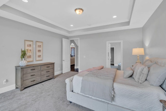 bedroom featuring a tray ceiling and light carpet