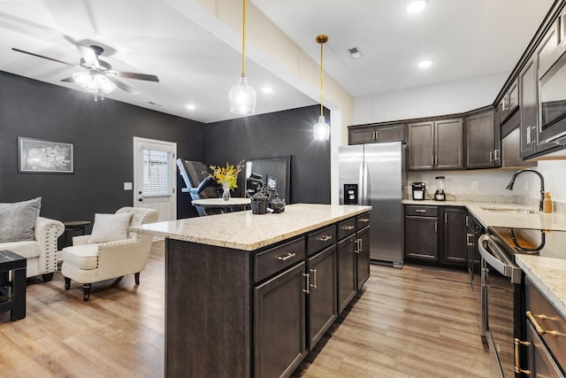 kitchen with pendant lighting, sink, light hardwood / wood-style flooring, dark brown cabinetry, and stainless steel appliances