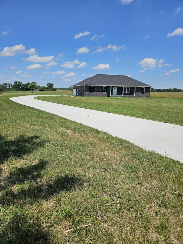 view of front of home with a rural view and a front lawn